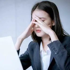 woman looking confused staring at a laptop screen