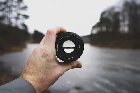 looking through a camera lens to bring view into sharp focus